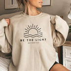 Women's crew neck sweatshirt with sun and wave graphic and Be the Light text