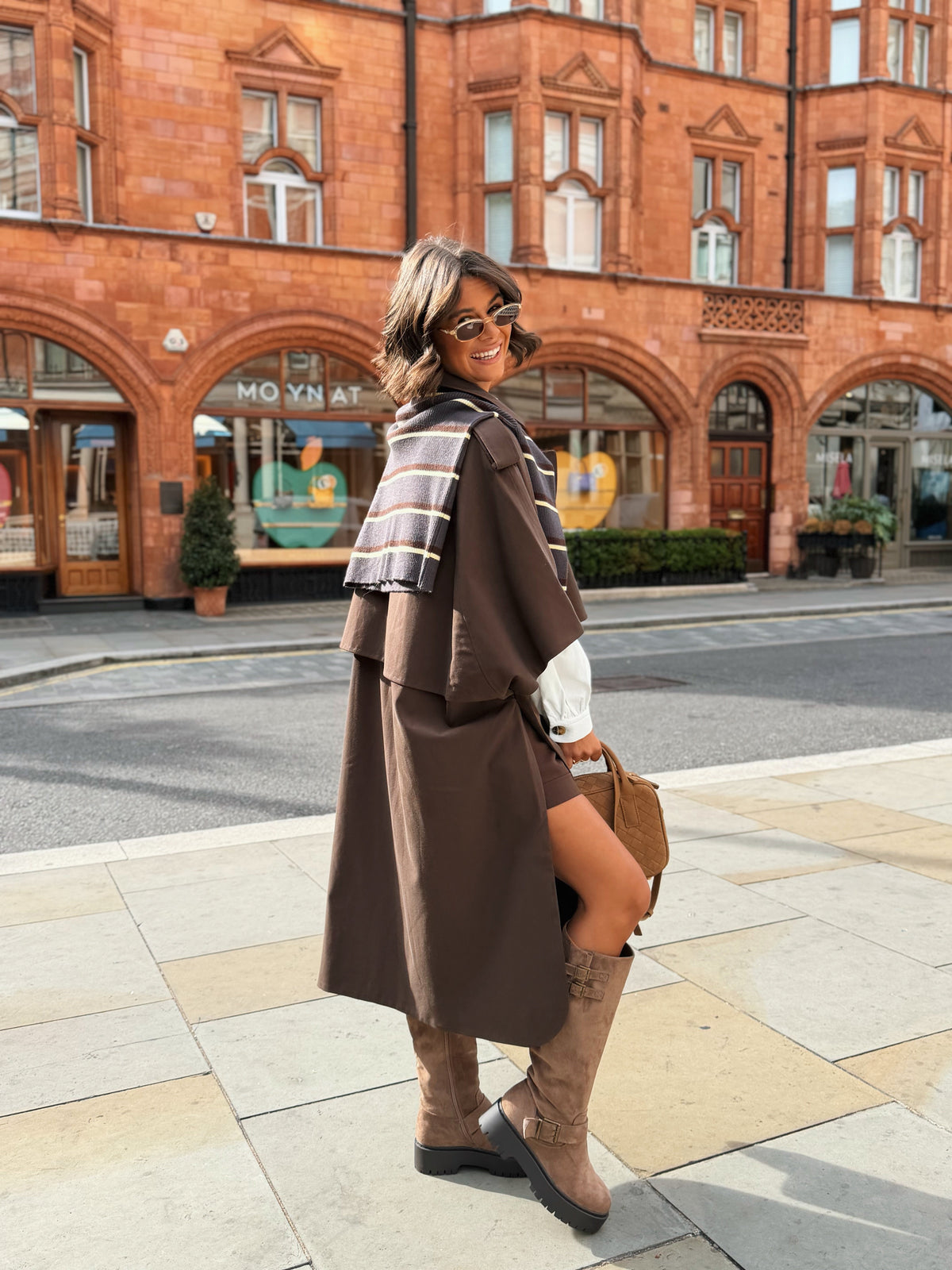 Women's brown long trench coat with wide lapels and cape-style sleeves