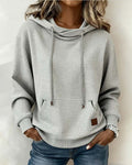Women's grey waffle-textured hooded sweatshirt with drawstrings and front kangaroo pocket