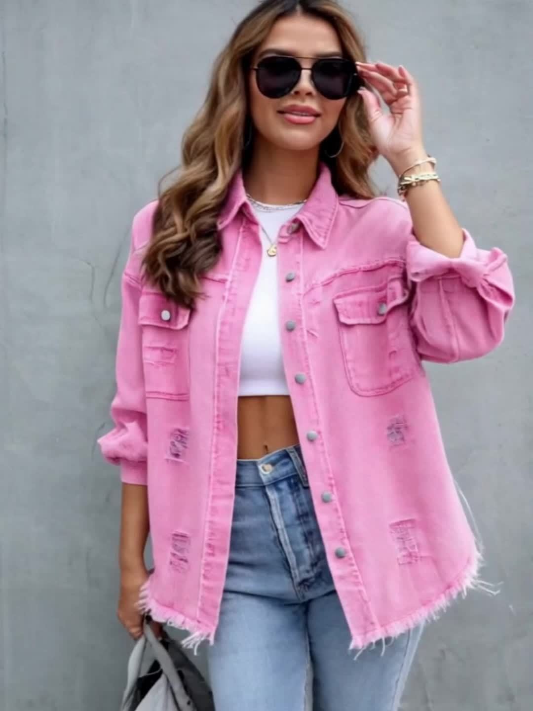 Women's pink distressed denim jacket with pockets and frayed hem