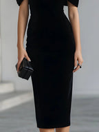 Women's black velvet midi dress with a large bow and sheer neckline