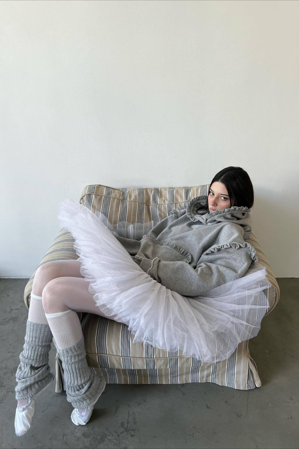 Women's grey pullover hoodie with ruffle trim around the hood and sleeves