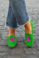 Green slip-on loafers with bright pink tassel details