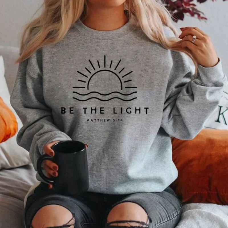 Women's crew neck sweatshirt with sun and wave graphic and Be the Light text