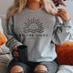 Women's crew neck sweatshirt with sun and wave graphic and Be the Light text