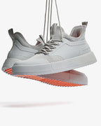 Grey low-top lace-up sneakers with mesh panels and flat sole