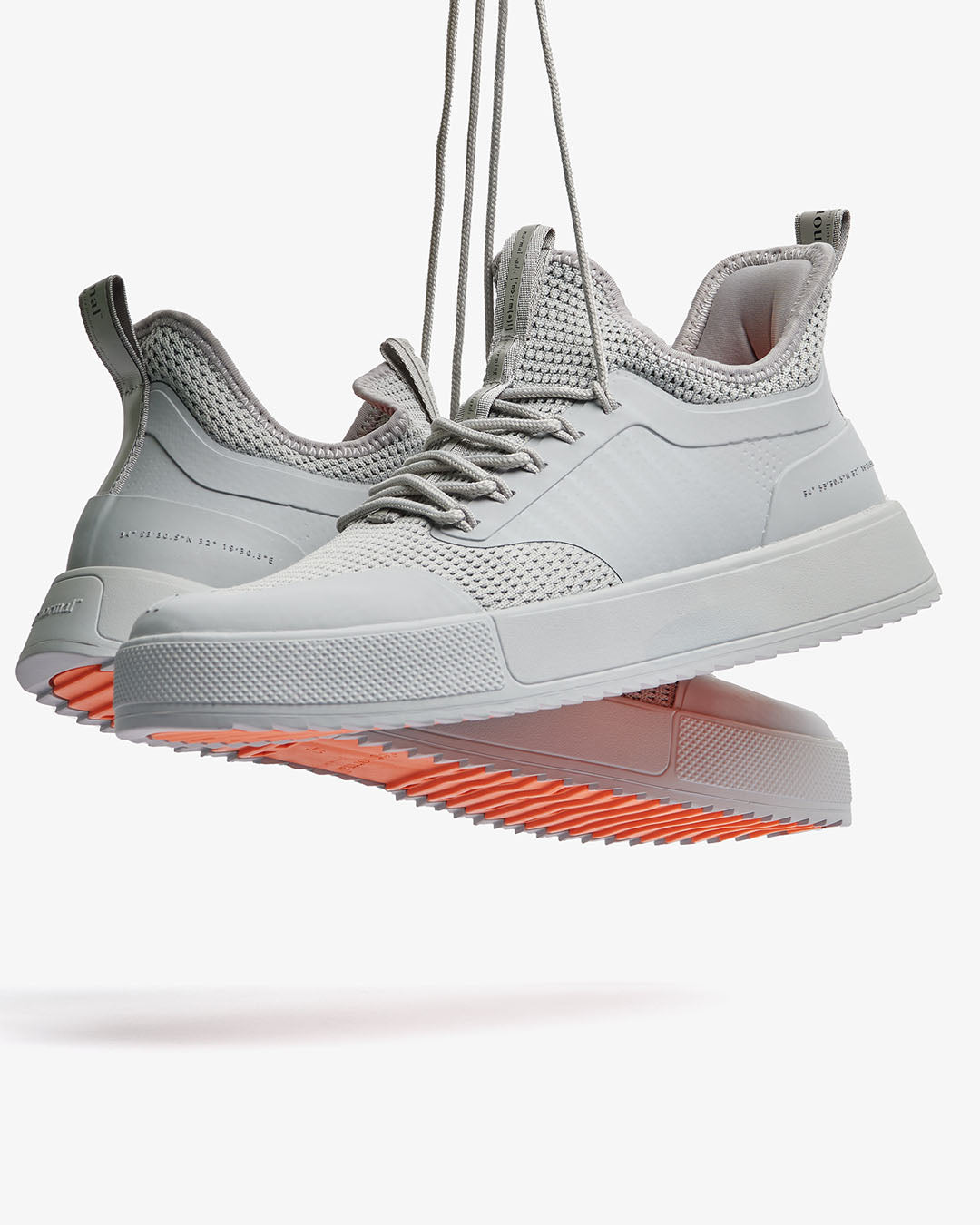 Grey low-top lace-up sneakers with mesh panels and flat sole