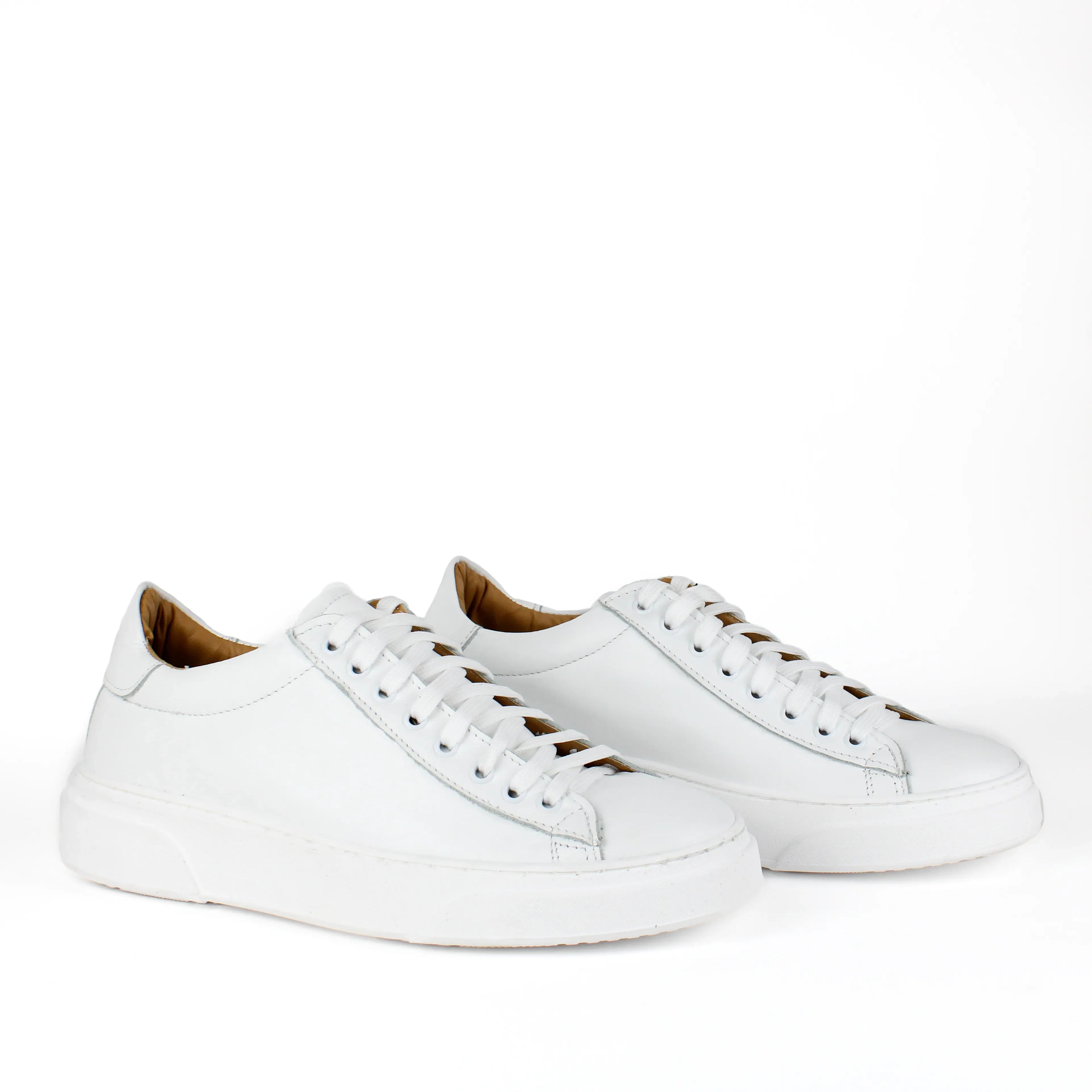White low-top leather sneakers with laces and thick flat soles