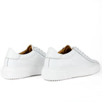 White low-top leather sneakers with laces and thick flat soles
