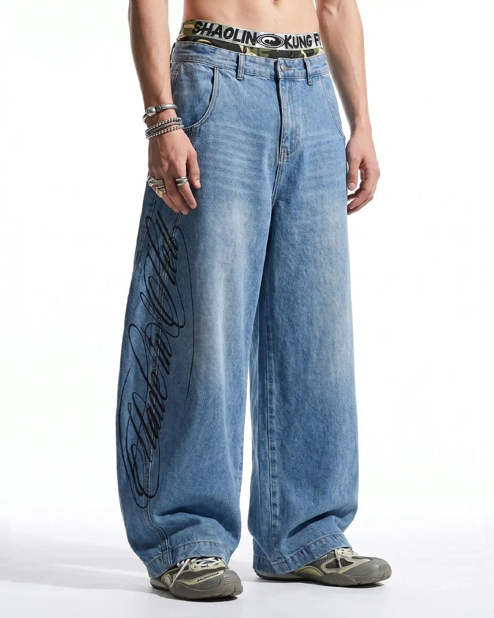 Light blue barrel jeans with script graphic on the left leg