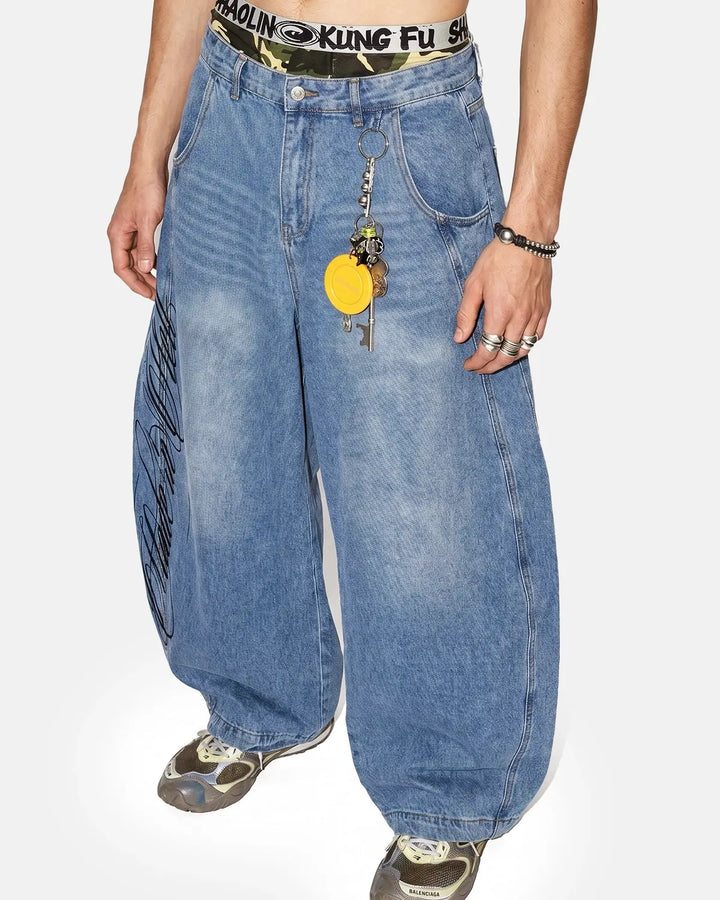 Light blue barrel jeans with script graphic on the left leg