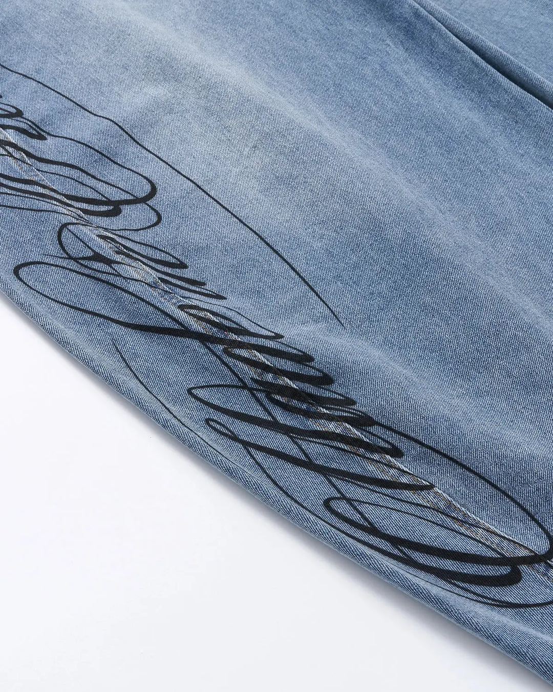 Light blue barrel jeans with script graphic on the left leg