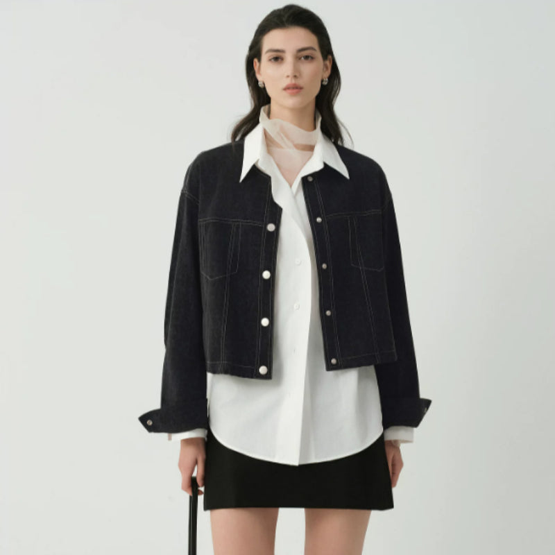 Women's cropped dark denim jacket with long sleeves and front pockets