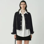 Women's cropped dark denim jacket with long sleeves and front pockets