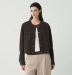 Women's cropped dark denim jacket with long sleeves and front pockets