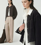 Women's cropped dark denim jacket with long sleeves and front pockets