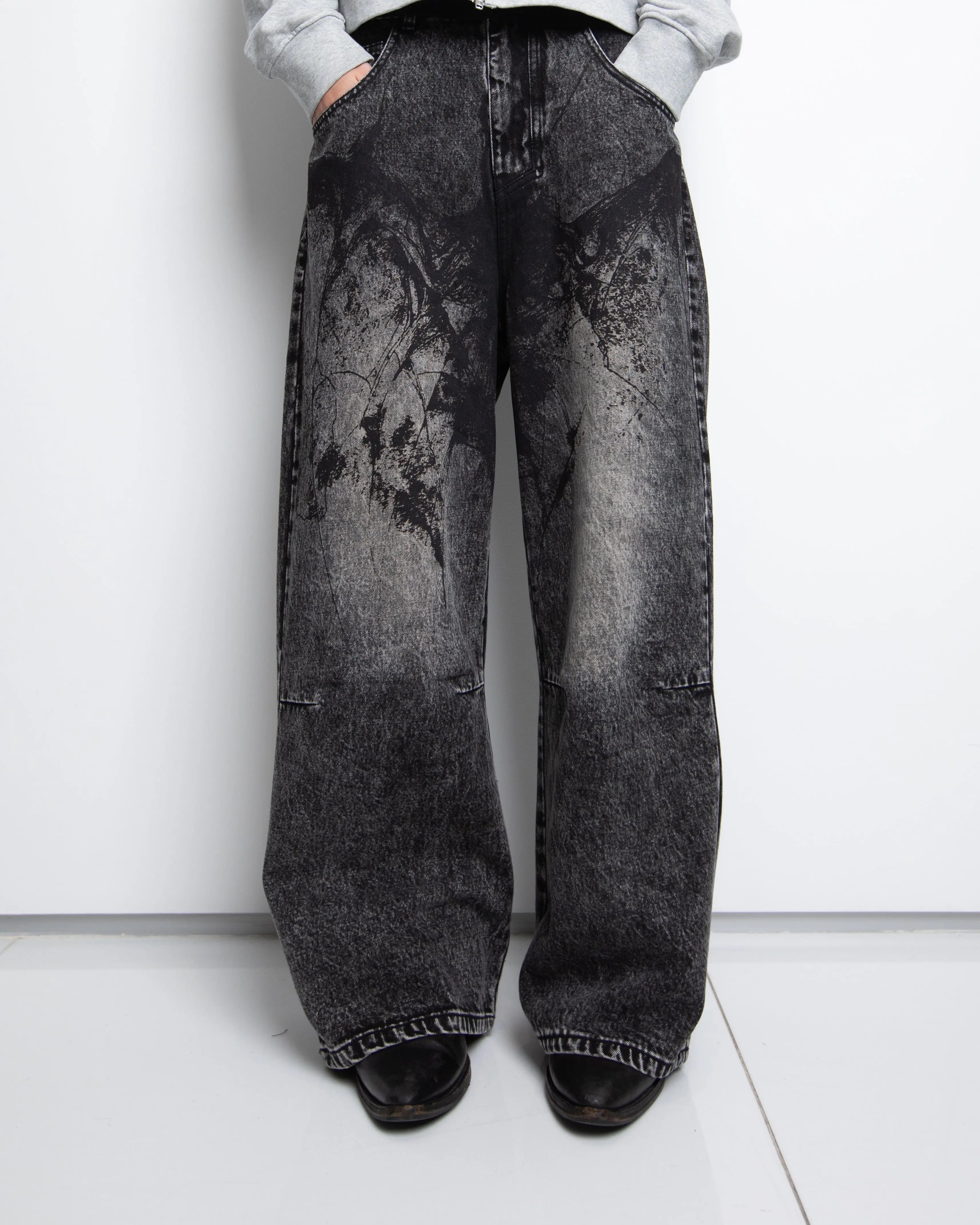 Women's black wide-leg jeans with graphic printed panels and flap pockets