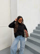 Women's black mock neck sweater with button details