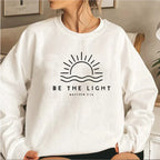 Women's crew neck sweatshirt with sun and wave graphic and Be the Light text