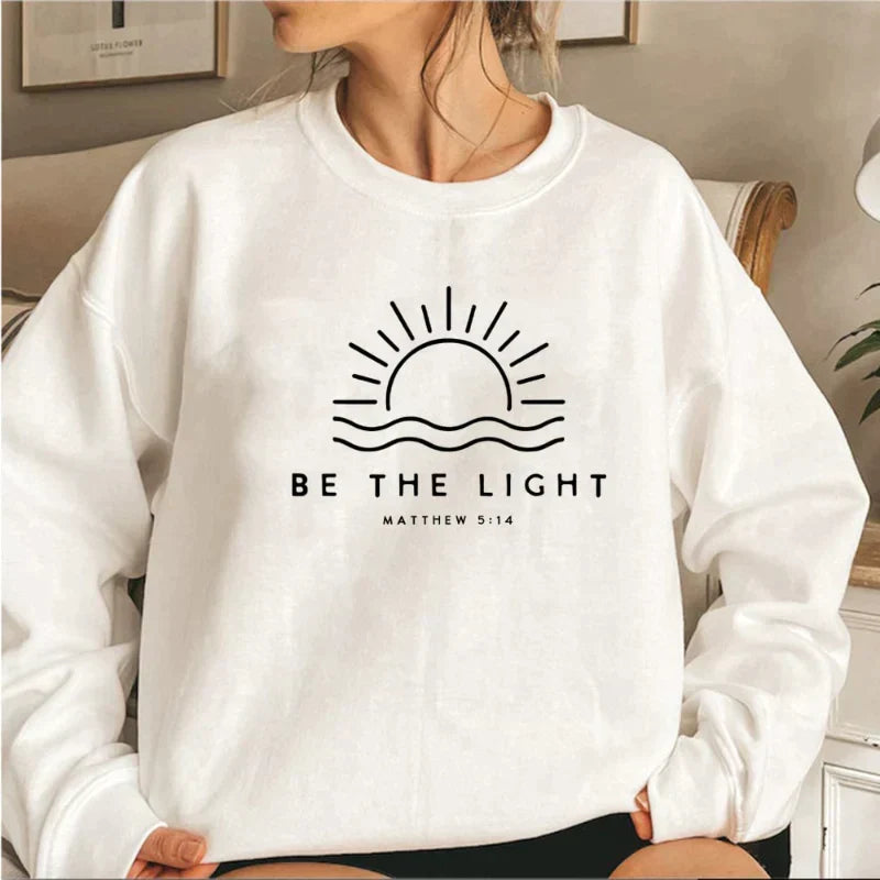 Women's crew neck sweatshirt with sun and wave graphic and Be the Light text