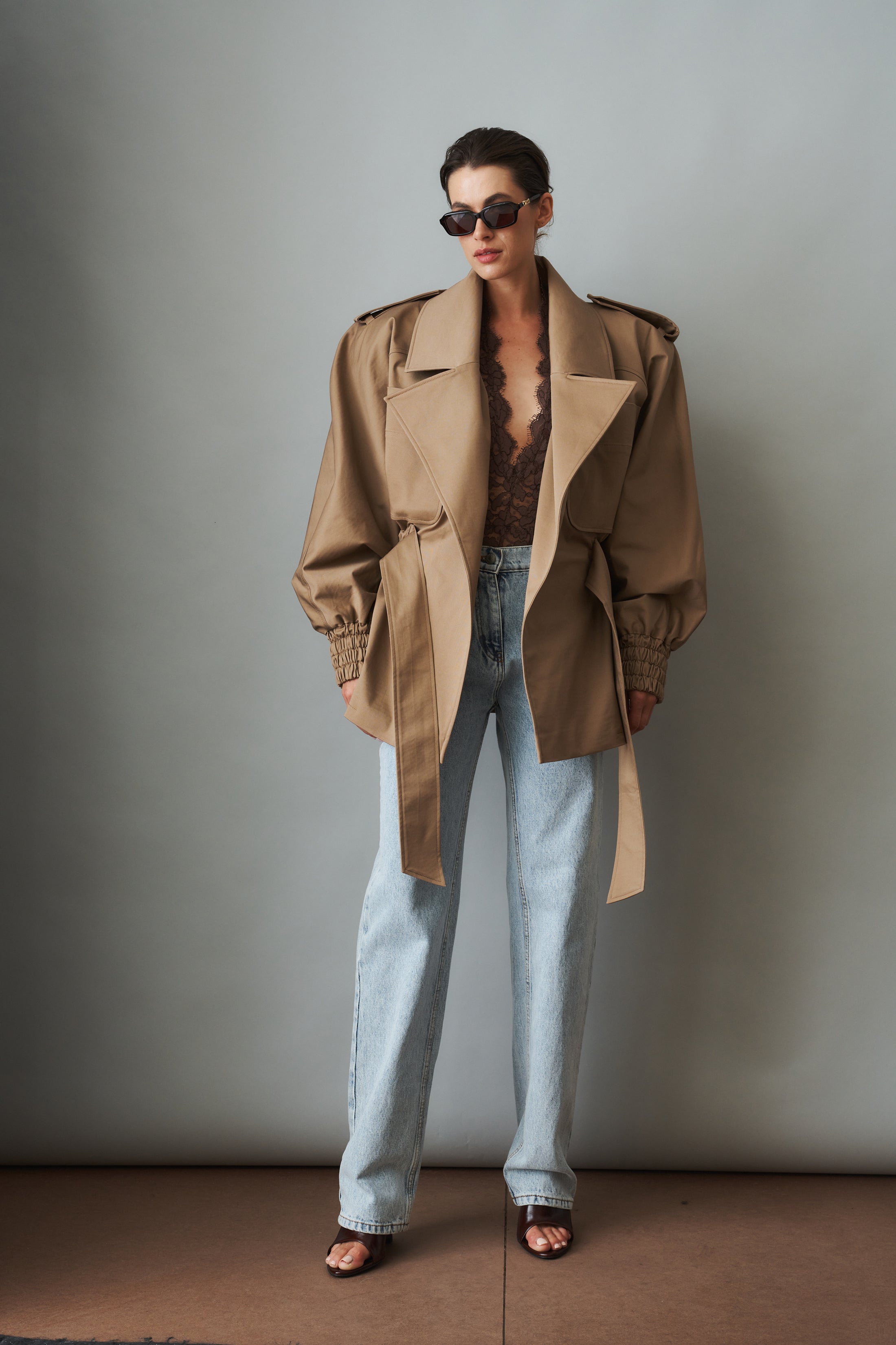 Women's khaki belted trench jacket with wide lapels and flap pockets