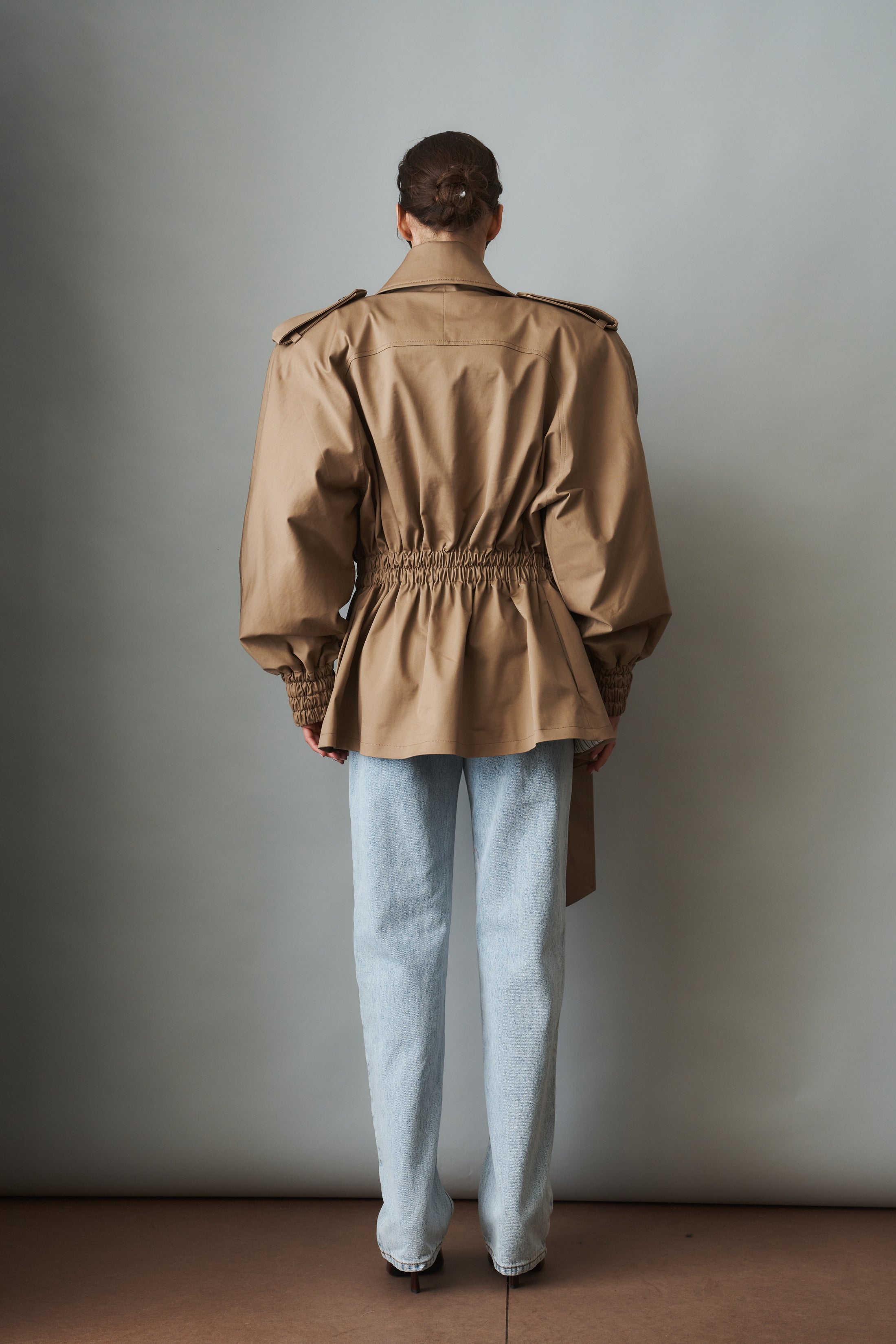 Women's khaki belted trench jacket with wide lapels and flap pockets