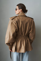 Women's khaki belted trench jacket with wide lapels and flap pockets