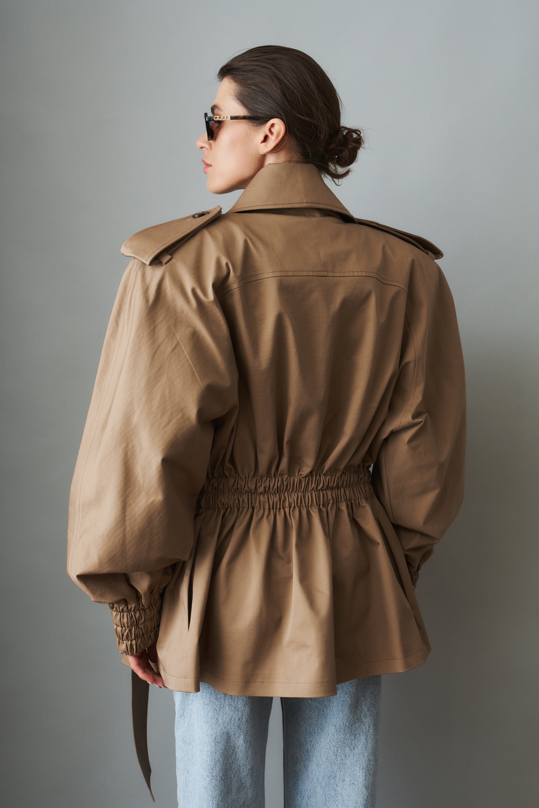 Women's khaki belted trench jacket with wide lapels and flap pockets