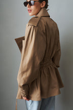 Women's khaki belted trench jacket with wide lapels and flap pockets