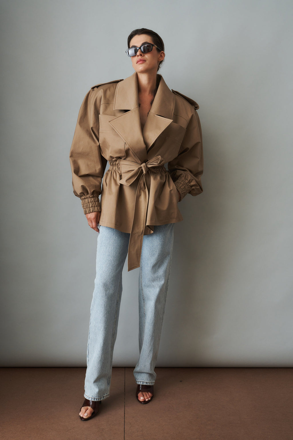 Women's khaki belted trench jacket with wide lapels and flap pockets