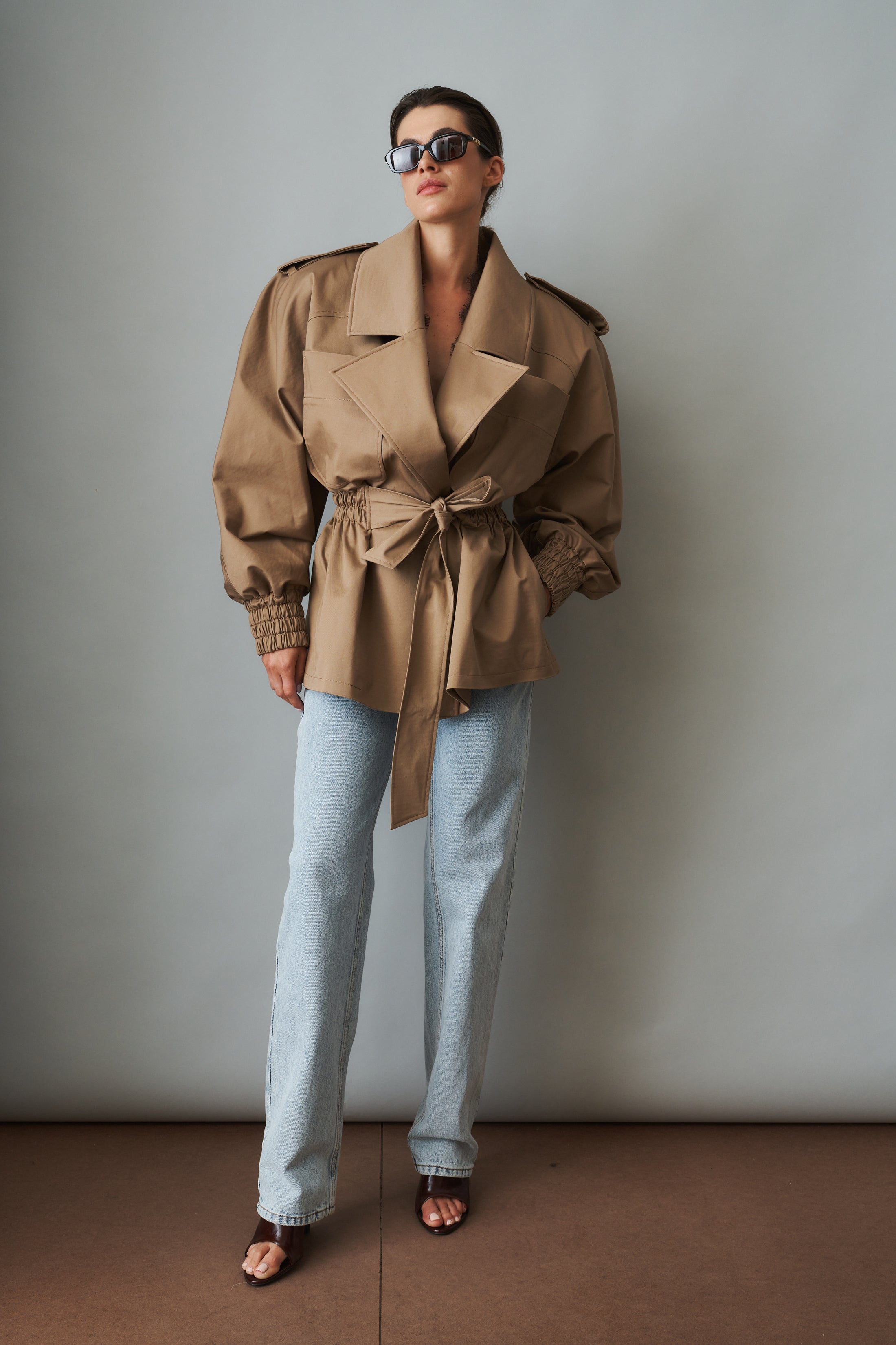 Women's khaki belted trench jacket with wide lapels and flap pockets