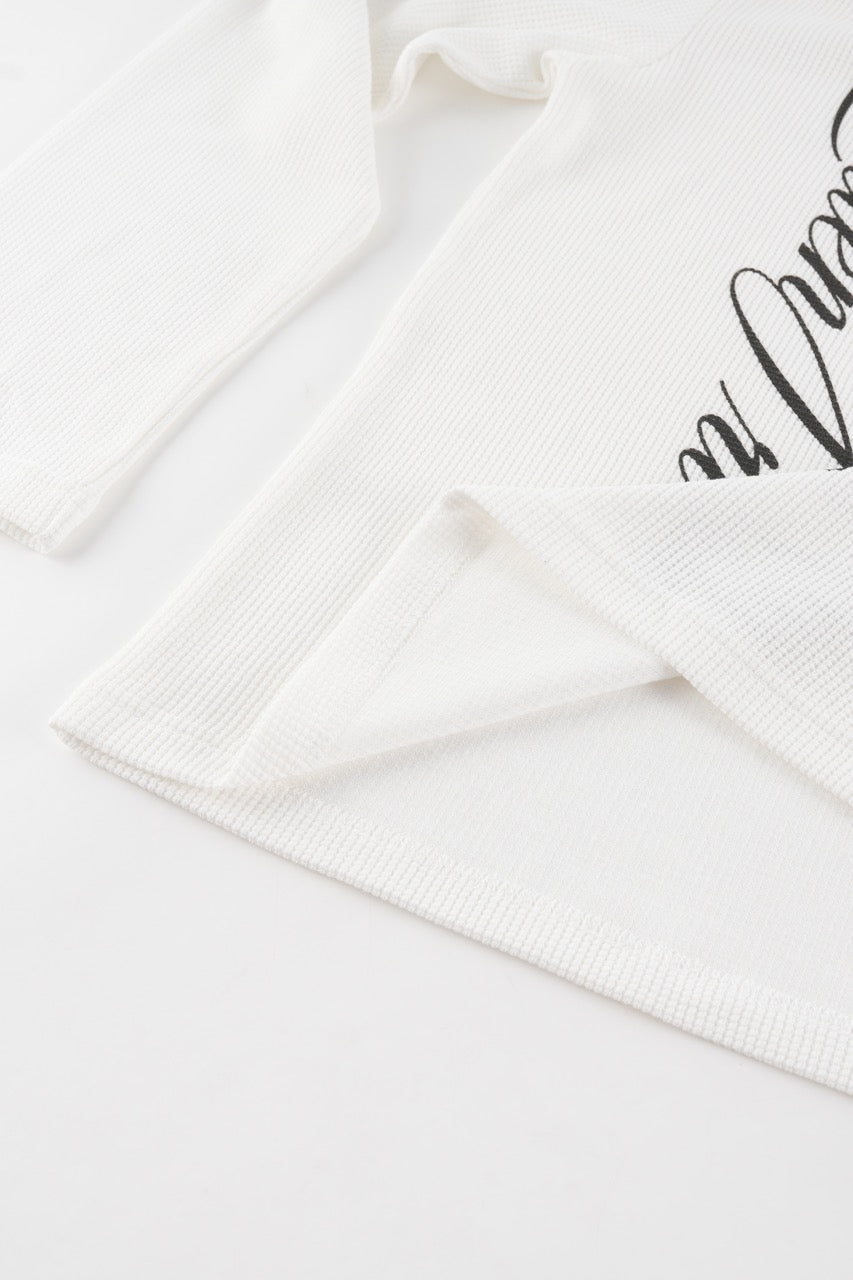 White waffle sweatshirt with black script graphic and long sleeves