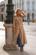 Women's long belted double-breasted trench coat with wide collar and cuff straps