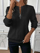 Women's textured cable knit sweater with round neckline and quarter-zip fastening