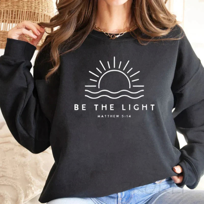 Women's crew neck sweatshirt with sun and wave graphic and Be the Light text