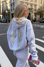 Women's relaxed hooded sweatshirt with sequin wing graphic on the back