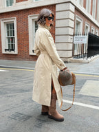 Women's beige long trench coat with high collar, buttons and tied waist belt