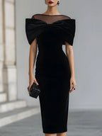Women's black velvet midi dress with a large bow and sheer neckline