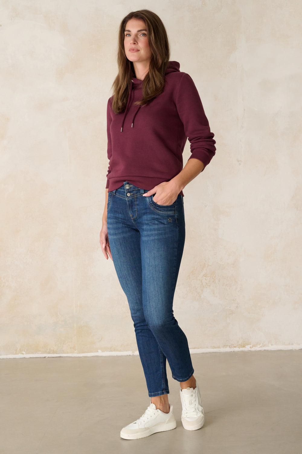 Women's blue slim fit jeans with mid-rise waist and ankle-length legs