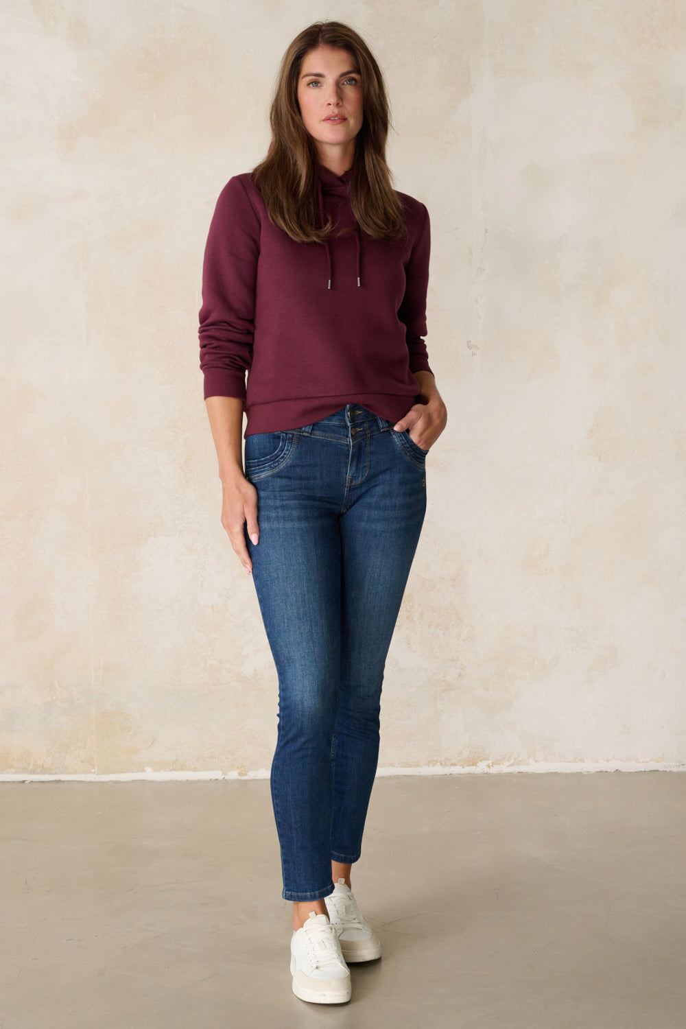 Women's blue slim fit jeans with mid-rise waist and ankle-length legs