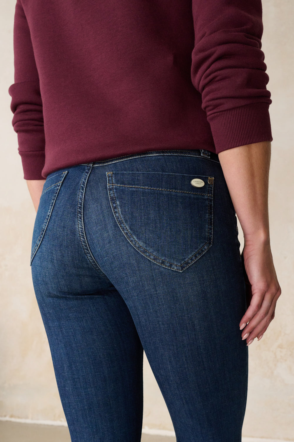 Women's blue slim fit jeans with mid-rise waist and ankle-length legs