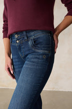 Women's blue slim fit jeans with mid-rise waist and ankle-length legs