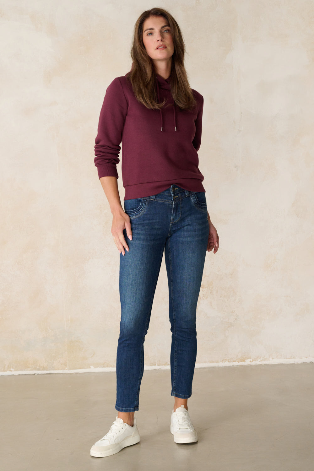 Women's blue slim fit jeans with mid-rise waist and ankle-length legs
