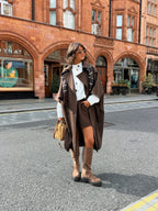 Women's brown long trench coat with wide lapels and cape-style sleeves