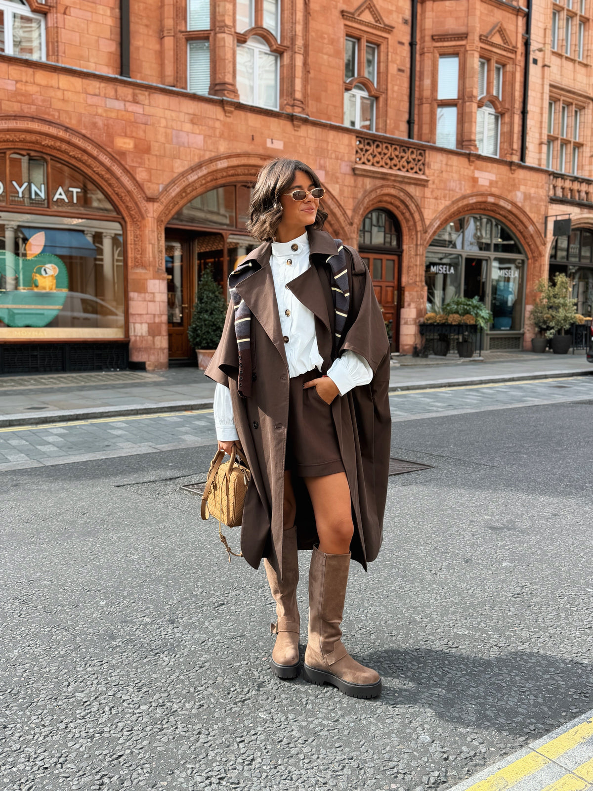 Women's brown long trench coat with wide lapels and cape-style sleeves