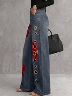 Women's high-waisted wide-leg jeans with red floral embroidery and gold eyelets