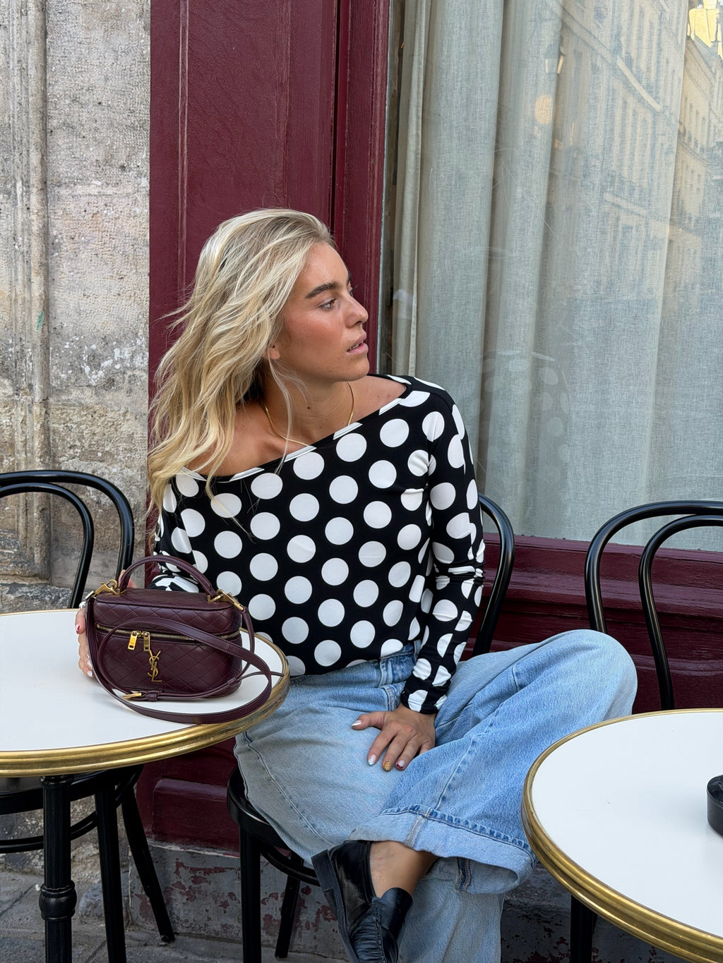 Women's black and white polka dot top with boat neckline and long sleeves