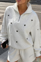Women's light gray half-zip sweatshirt with black heart studs
