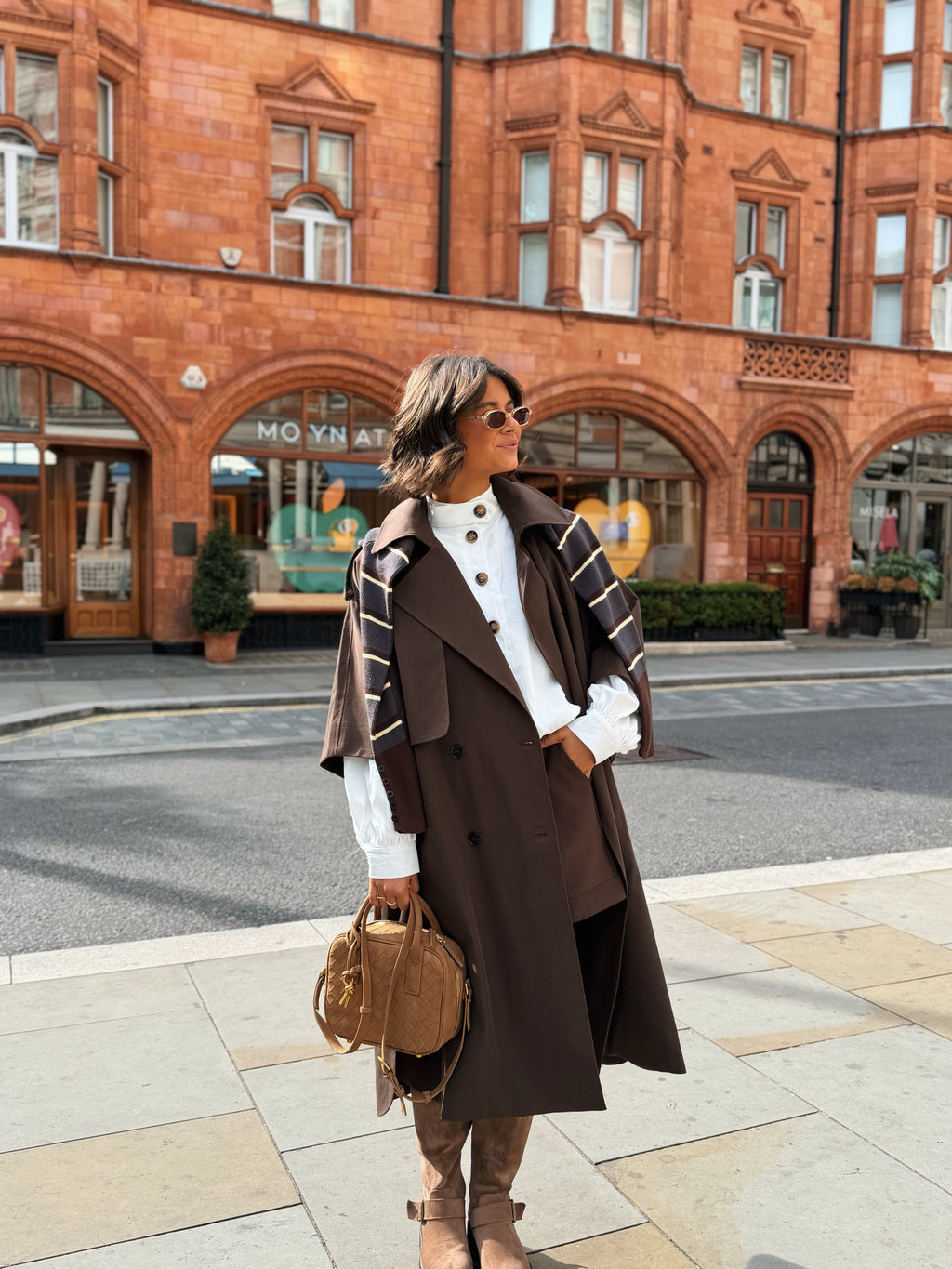 Women's brown long trench coat with wide lapels and cape-style sleeves