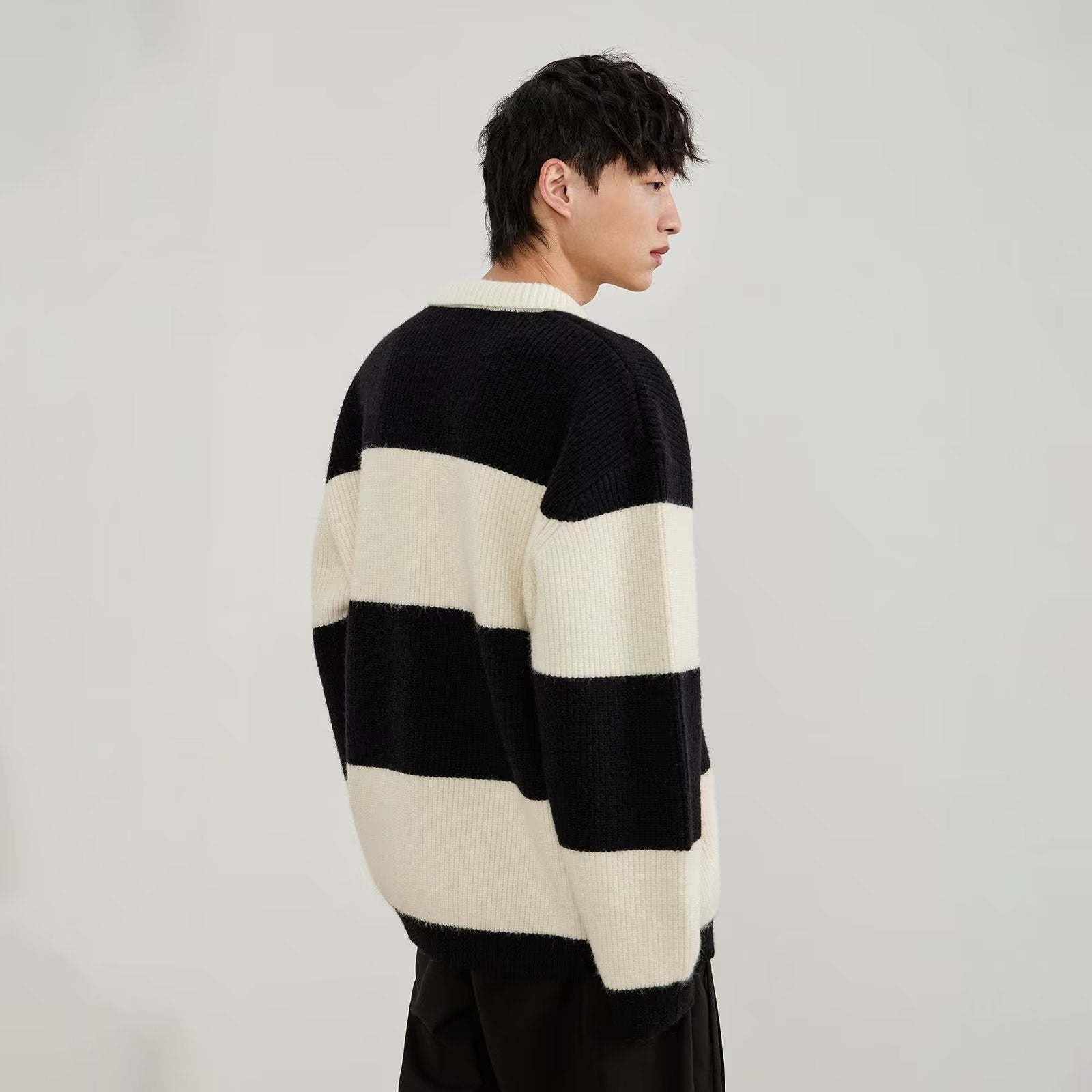 Men's black and cream striped polo sweater with long sleeves and button placket